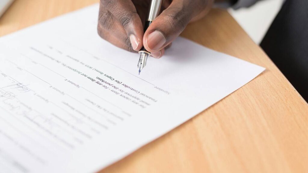A black man signing a document