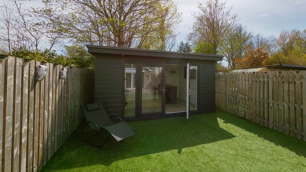 A photo of a modern garden room situated in the backyard
