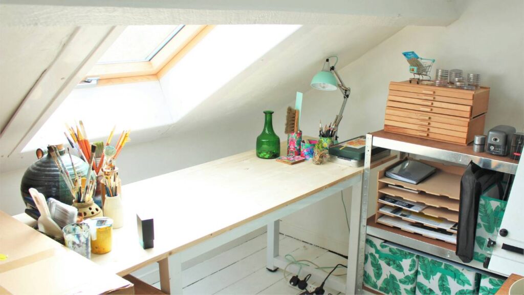 A white work desk in a well-lit attic
