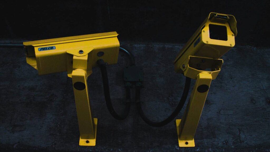 Two yellow surveillance cameras on a wall