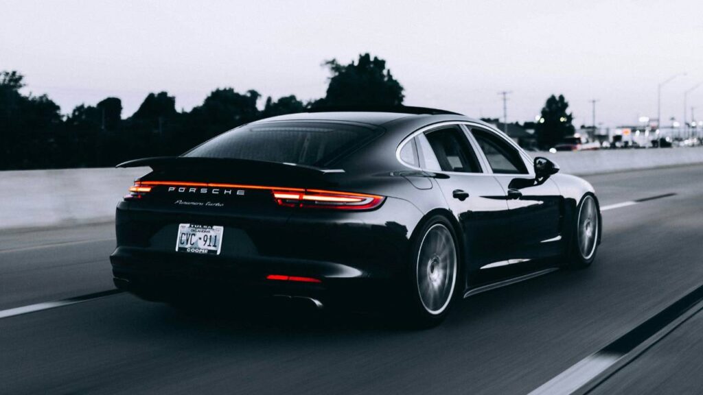 A black Porsche automobile on the highway