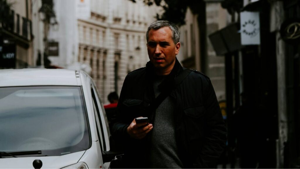 A businessman using his phone while walking down the street