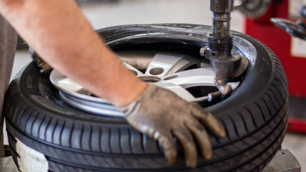 A handyman working on a vehicle tyre