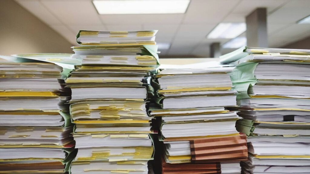 Several piles of file folders full of documents