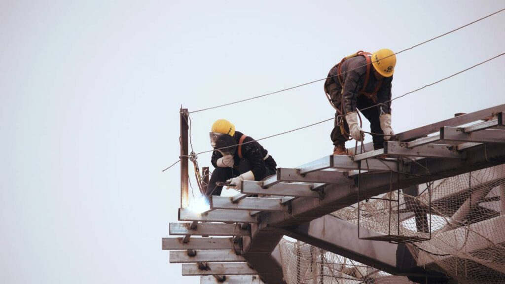 Two workers photographed at a construction site