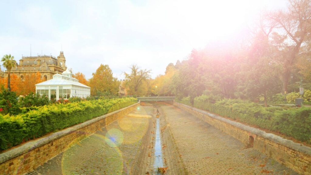 A photo of a small canal filled with water next to a mansion 