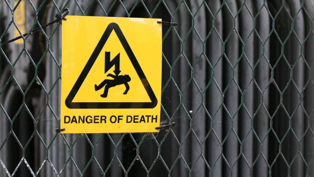 A fence with a "danger of death" sign on it